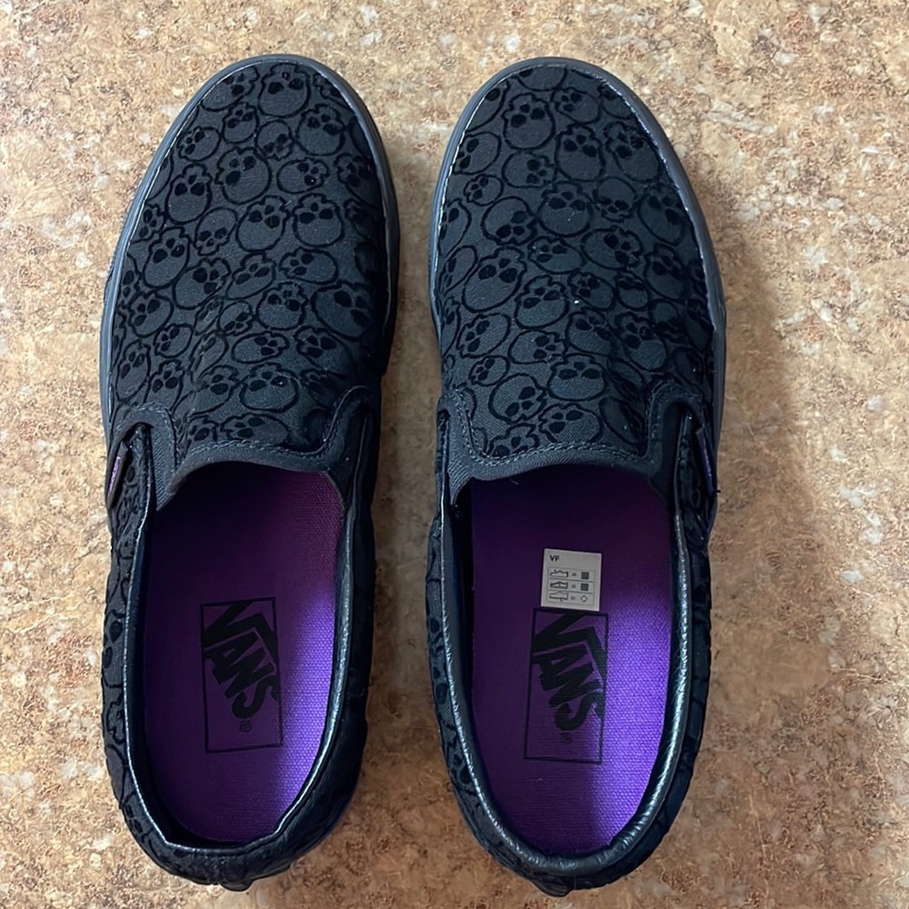 Black slip-on vans with suede skeleton pattern